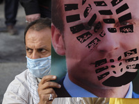 An Iranian protester holds an anti French President Emmanuel Macron placard during a protest gathering in front of the French embassy in Teh...