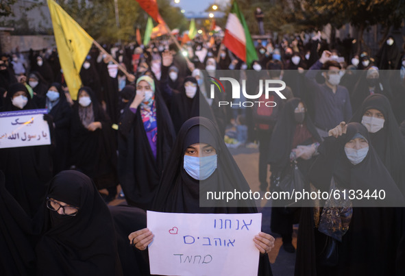 An Iranian female protester holds a placard with a Hebrew script that reads, I Love Mohammad, during a protest gathering in front of the Fre...