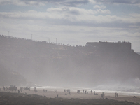 people watch surfer on the north beach, in Nazaré, on the day a giant swell is expected, on October 29, 2020, Nazaré, Portugal (