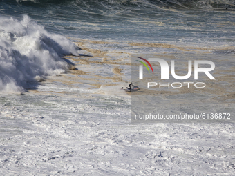 Surfer catches a giant swell wave at Praia do Norte, in Nazaré, on October 29, 2020 (