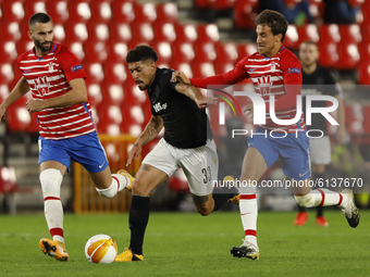 Maxime Gonalons and Luis Milla of Granada CF defend Douglas Augusto Soares Gomes of PAOK FC during the UEFA Europa League Group E stage matc...