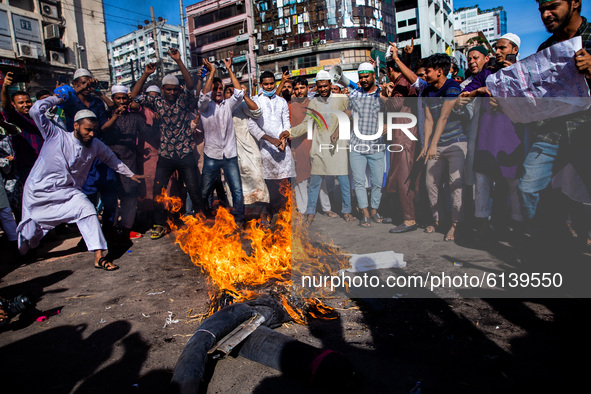 Muslims burn an effigy of French president Emmanuel Macron with shoes as they take part in a protest calling for the boycott of French produ...