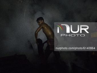 A residence work to extinguish a fire that broke out in a slum in Dhaka on October 30, 2020.  (
