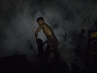A residence work to extinguish a fire that broke out in a slum in Dhaka on October 30, 2020.  (