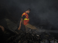 A volunteer work to extinguish a fire that broke out in a slum in Dhaka on October 30, 2020.  (