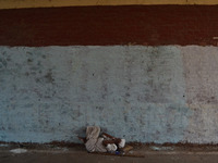 An indian old man takes rest under a footover bridge during a hot day in Allahabad on June 1,2015. (