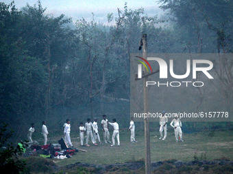 Cricketers warm up before a practice session amid a layer of smoky haze, as the air quality of the national capital hit 'very poor' levels d...