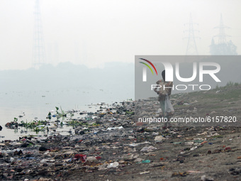 Children search for recyclable items near Yamuna river amid a layer of smoky haze, as the air quality of the national capital hit 'very poor...