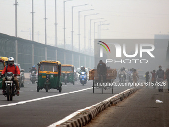 Vehicular traffic passing through amid a layer of smoky haze, as the air quality of the national capital hit 'very poor' levels due to stubb...