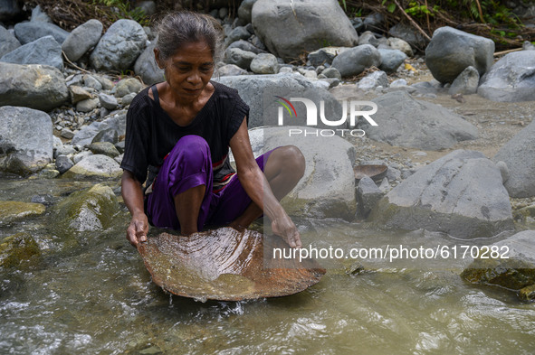 A mother panning gold with traditional tools in Powelua Village, Donggala Regency, Central Sulawesi Province, Indonesia on November 8, 2020....