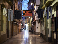 View of Calle Navas, one of the main streets of restaurants and bars of Granada, empty with a clothesline with a sign that says 