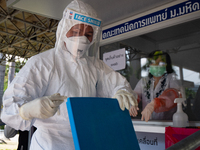 A health worker collects a nasal swab sample from people at Ministry of Public Health on November 9, 2020 in Bangkok, Thailand. (