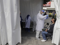 Medical personnel perform free tests of COVID-19 antigens to people who request it at a health macro kiosk located outside the Ethiopia metr...