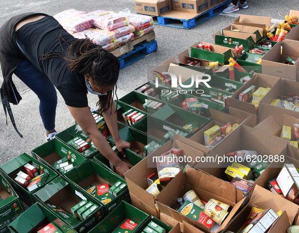 A volunteer prepares food for distribution to the needy which was donated by the Second Harvest Food Bank of Central Florida and the City of...
