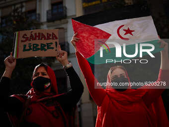 Women wearing face mask, carrying a Saharan flag and a placard that says ‘Free Sahara’ and dressed in Malahfas during a demonstration to dem...
