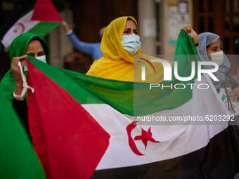 Women wearing face mask carrying a Saharan flag and dressed in Malahfas during a demonstration to demand the end of Morocco's occupation in...