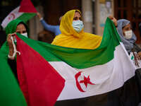 Women wearing face mask carrying a Saharan flag and dressed in Malahfas during a demonstration to demand the end of Morocco's occupation in...