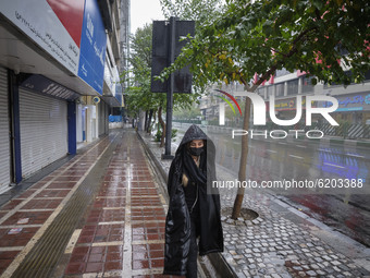 An Iranian woman wearing a protective face mask walks along an avenue as shops are closed in Tehran’s downtown, following the new coronaviru...