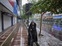 An Iranian woman wearing a protective face mask walks along an avenue as shops are closed in Tehran’s downtown, following the new coronaviru...