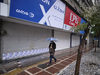 An Iranian man wearing a protective face mask walks along an avenue as shops are closed in Tehran’s downtown, following the new coronavirus...