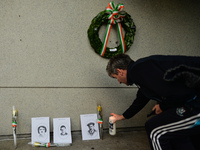 A man lays a candle near images of Bloody Sunday victimes placed outside Croke Park in Dublin during a commemoration event organised by 'The...