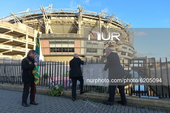 Two men fixing posters with names of Bloody Sunday victimes to the fence outside Croke Park in Dublin, during a commemoration event organise...