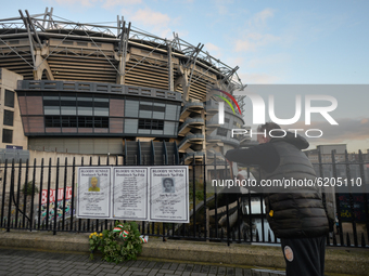 A man takes a picture of posters with names of Bloody Sunday victimes to the fence outside Croke Park in Dublin, during a commemoration even...