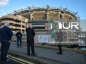 People seen near posters with names of Bloody Sunday victimes attached to the fence outside Croke Park in Dublin, during a commemoration eve...