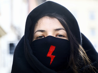 A woman wearing a face mask with Women Strike symbol attends a demonstration against Cardinal Stanislaw Dziwisz who allegedly ignored cases...