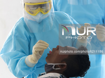 A Sri Lankan Health worker in a protective suit takes a throat swab of a man for a COVID-19 test  at Colombo, Sri Lanka. Monday 23 2020.
Sr...