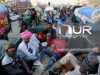 Farmers sitting on the blocked road during a protest against the Centre's new farm laws at Singhu border near Delhi, India on November 27, 2...