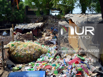 An indian rag-picker child collects plastic bottles in a garbage dump in Allahhabad  on June 5 ,2015,World Environment day.World environment...