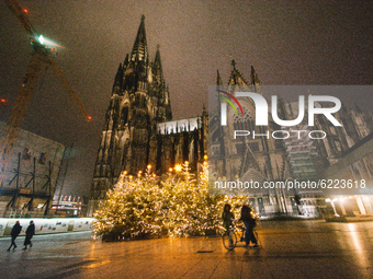 Christmas trees are illuminated in front of Dom cathedral in Cologne, Germany, on November 27, 2020.  (
