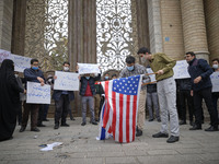 Protesters prepare an Israeli and the U.S. flags to set on fire during a protest gathering against the assassination of the Iranian Top nucl...