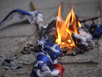 Protesters burn the U.S. flags during a protest gathering against the assassination of the Iranian Top nuclear scientist and a member of the...