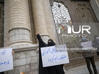A female veiled protester (C) gestures as she holds a placard with a Persian script that said, Implement the NPT must be stope, during a pro...