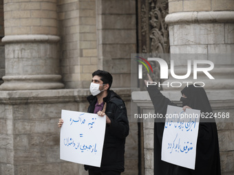 A female veiled protester (R) gestures as she holds a placard with a Persian script that said, Implement the NPT must be stope, during a pro...