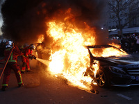 A firefighter tries to put out a car fire in Paris on November 28, 2020 during a protest against the ''global security'' draft law, which Ar...