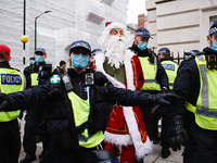 An anti-lockdown activist dressed as Father Christmas is arrested in Grosvenor Square during a demonstration in London, England, on November...