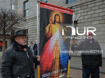 Two men hold an image of Jesus Christ during a 'Rosary Rally' outside the GPO on O'Connell Street, on day 39 of the nationwide Level 5 lockd...