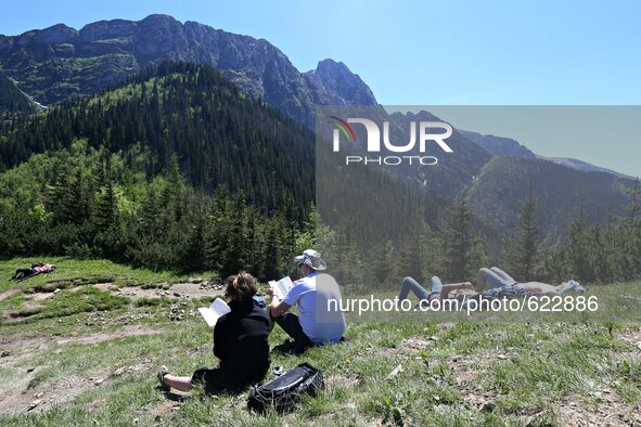  Tatry Mountains in South site of Poland. 05 Jun, 2015, Zakopane
People rest and read books on a mountain slope 