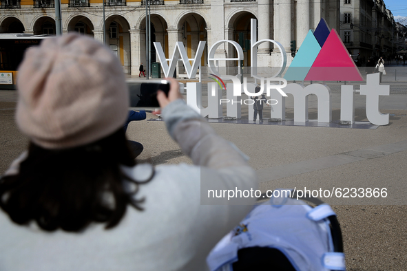 A woman takes a picture of her son in front a 3D logo of Web Summit in downtown Lisbon, Portugal on November 30, 2020. Web Summit, Europes b...