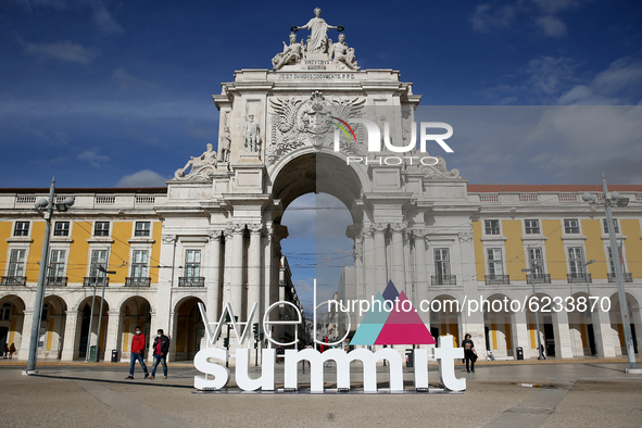 People wearing face masks walk past a 3D logo of Web Summit in downtown Lisbon, Portugal on November 30, 2020. Web Summit, Europes biggest t...