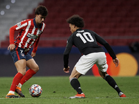 Joao Felix of Atletico Madrid and Leroy Sane of Bayern compete for the ball during the UEFA Champions League Group A stage match between Atl...