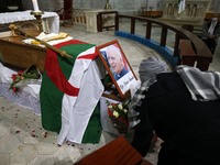 A woman kneels near the coffin of the late Algerian Archbishop Henri Teissier at Notre-Dame d'Afrique cathedral in Algiers on December 9, 20...