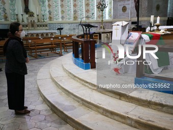 A man kneels near the coffin of late Algerian Archbishop Henri Teissier on December 9, 2020 before a mass in his honour in Algiers on the ev...