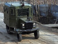 An Indian military vehicle moves towards the gun-battle site in Wanigam Payeen village of north Kashmir's Baramulla district on December 24,...