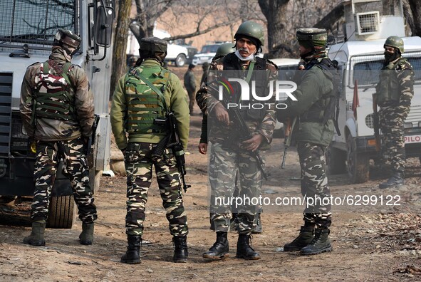 Indian security forces stand near the gun-battle site in Wanigam Payeen village of north Kashmir's Baramulla district on December 24, 2020....