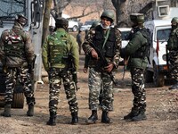 Indian security forces stand near the gun-battle site in Wanigam Payeen village of north Kashmir's Baramulla district on December 24, 2020....