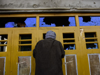 A Kashmiri man looks inside a damaged residential house in Kanigam Village of Shopian district, South of Srinagar, Indian Administered Kashm...